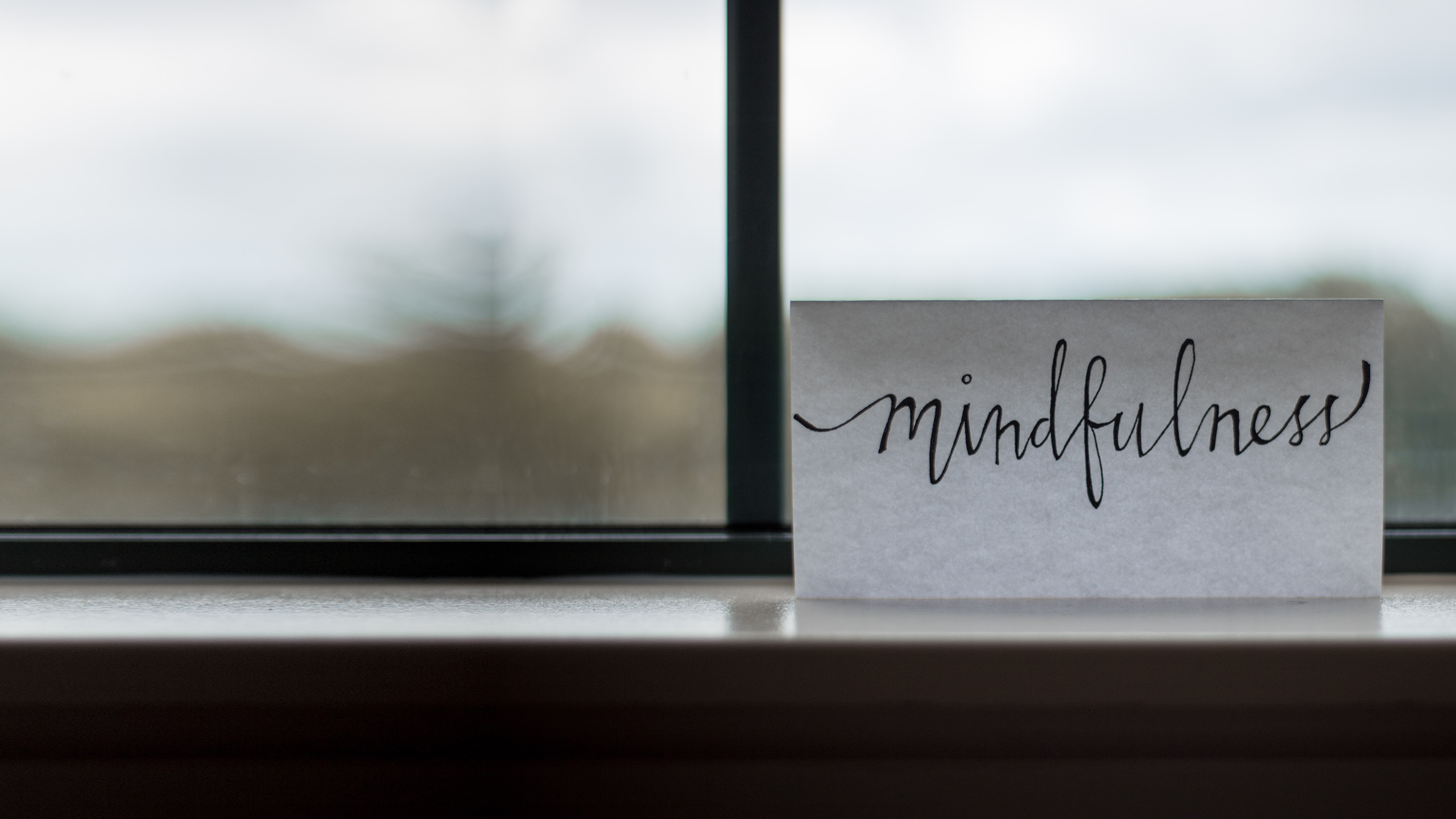 Ein Blatt Papier mit dem Wort mindfulness vor einem Fenster